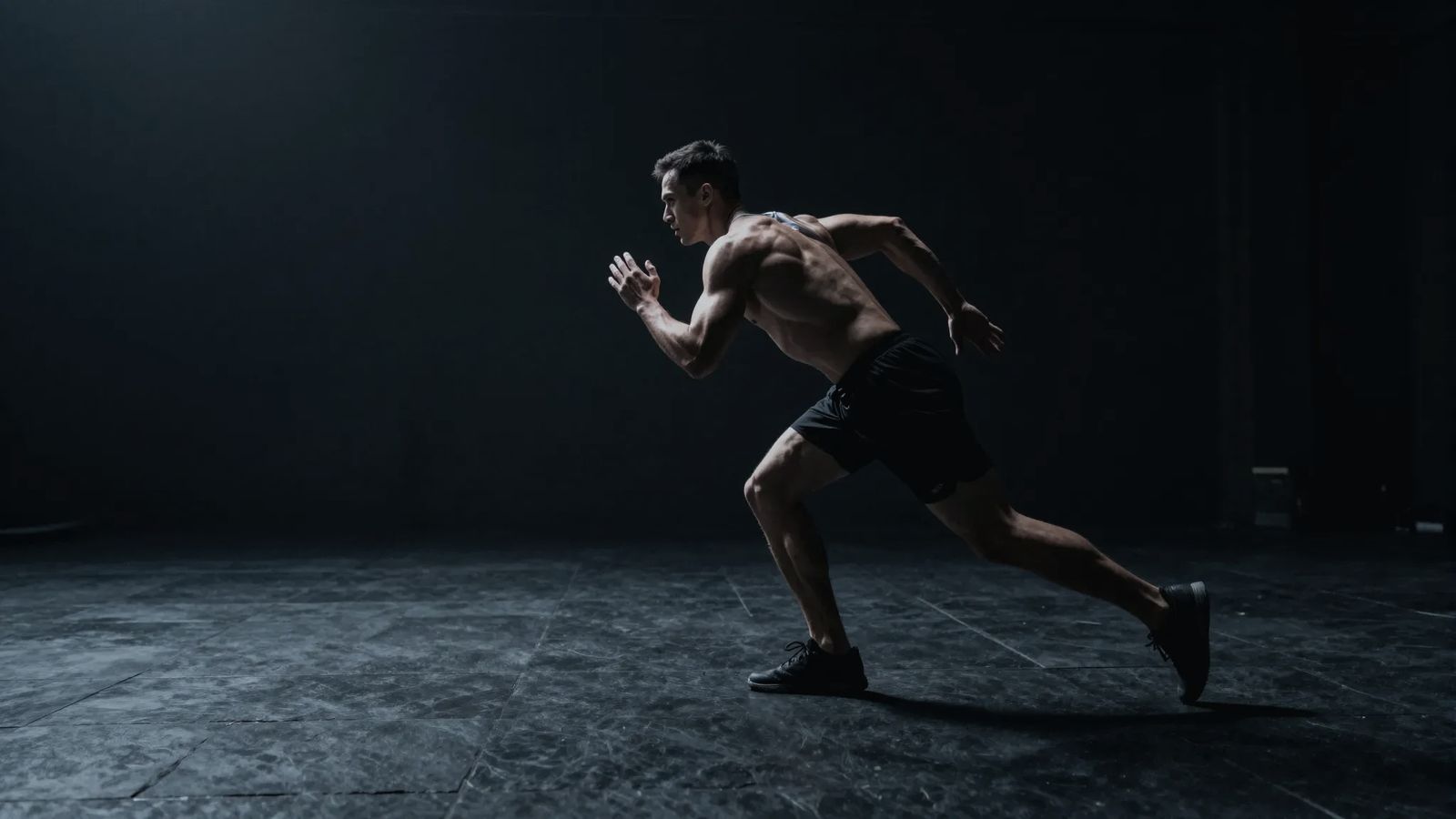 Athlete sprinting in a dark gym